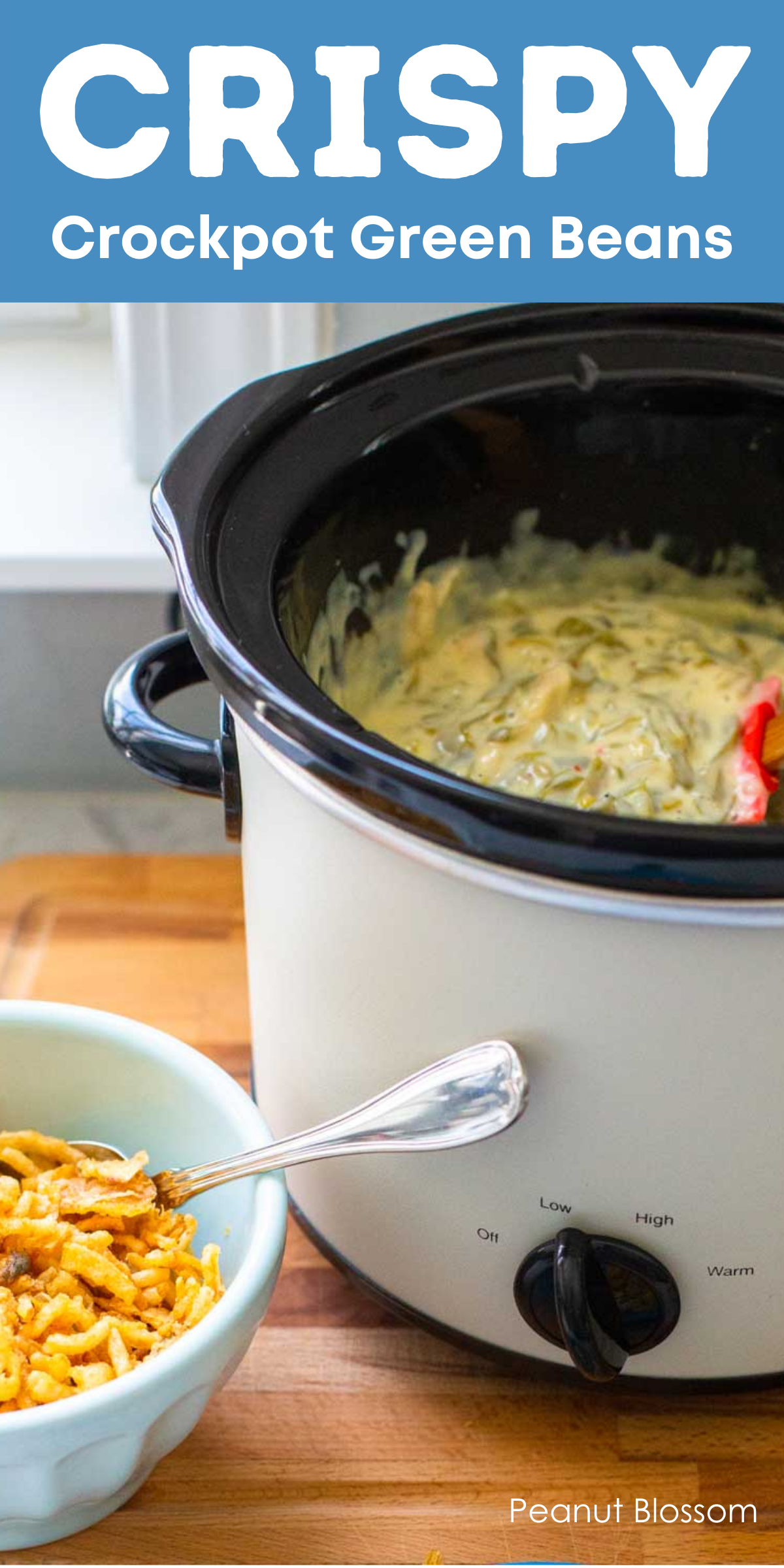 A Crockpot filled with green bean casserole sits next to a small bowl of crispy fried onions for topping.