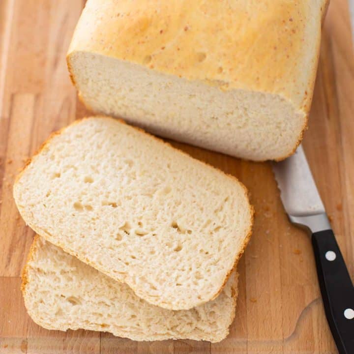 A loaf of sourdough bread from the bread machine has been sliced to show the texture of the bread.