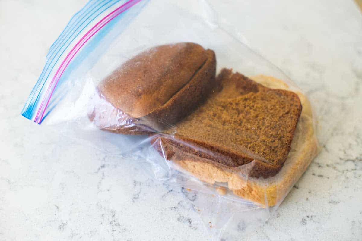 The ends of homemade bread are stored in a plastic bag for the freezer.