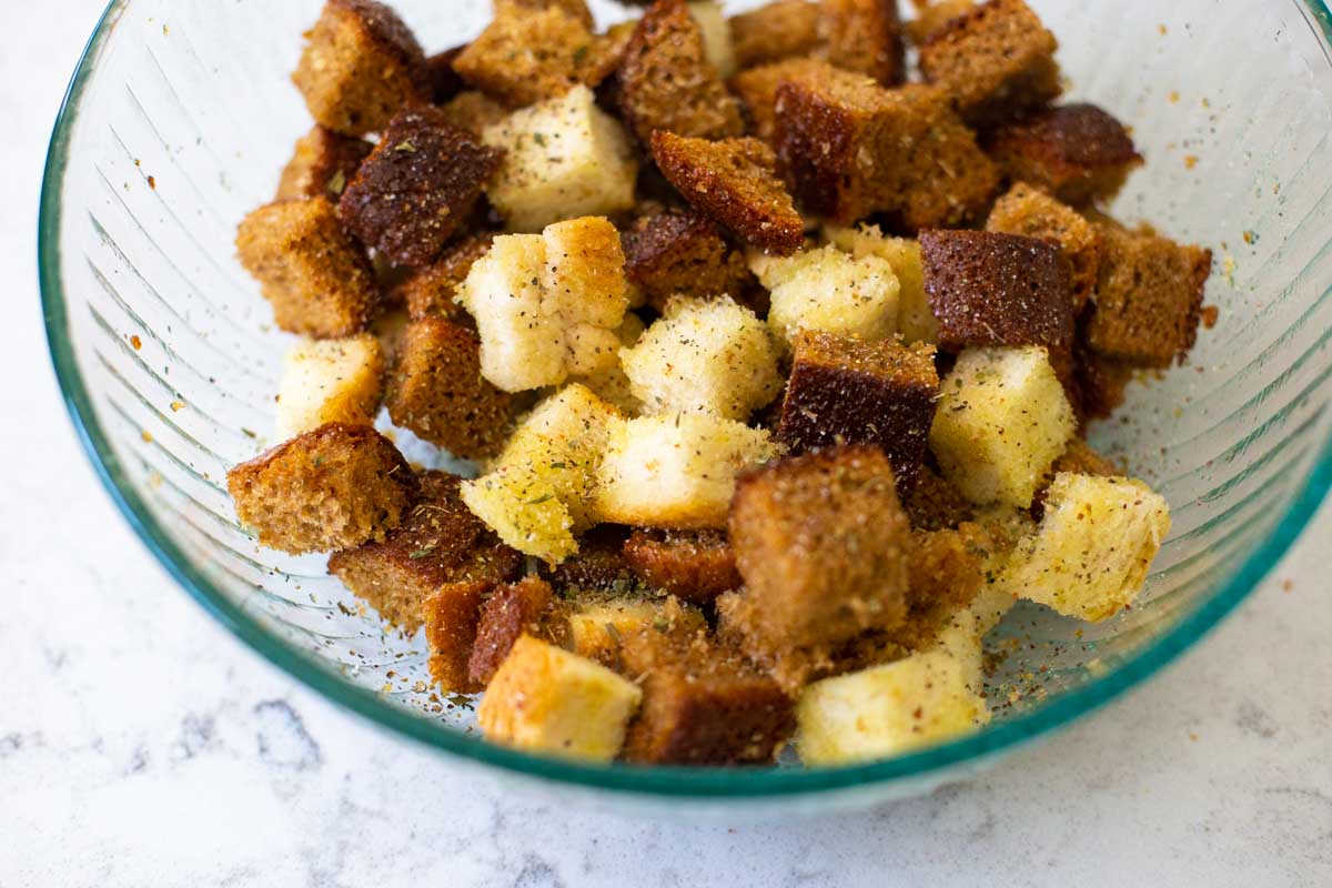 The bread cubes have been tossed in olive oil and sprinkled with seasonings.