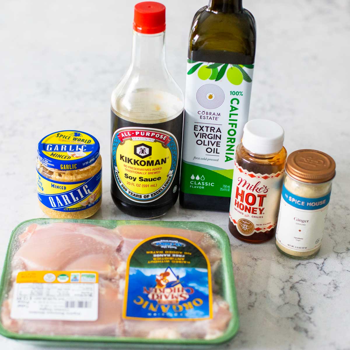 The honey garlic marinade ingredients sit next to a package of chicken thighs.