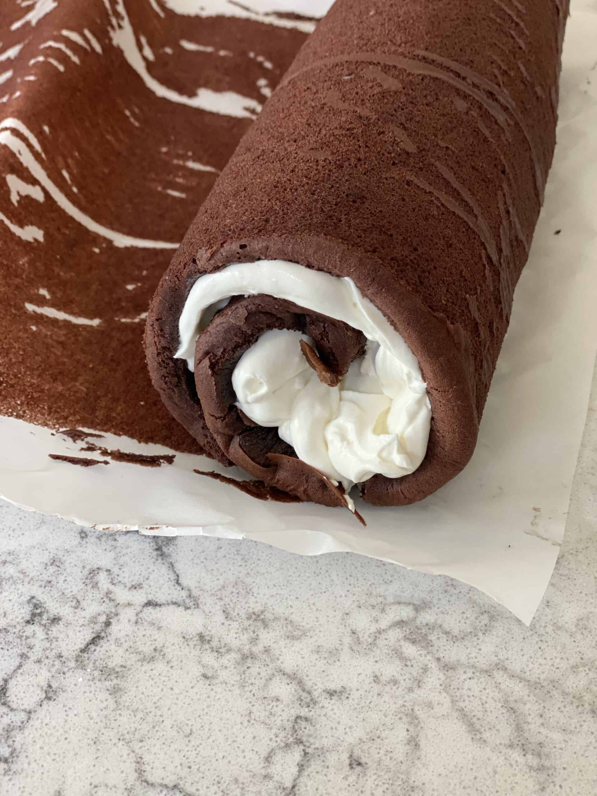 Use the parchment paper to roll up the yule log and chill.
