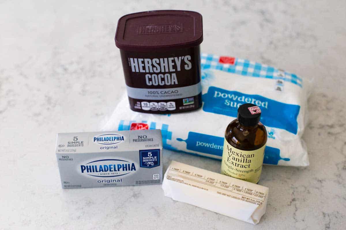 The ingredients for chocolate cream cheese frosting are on the kitchen counter.