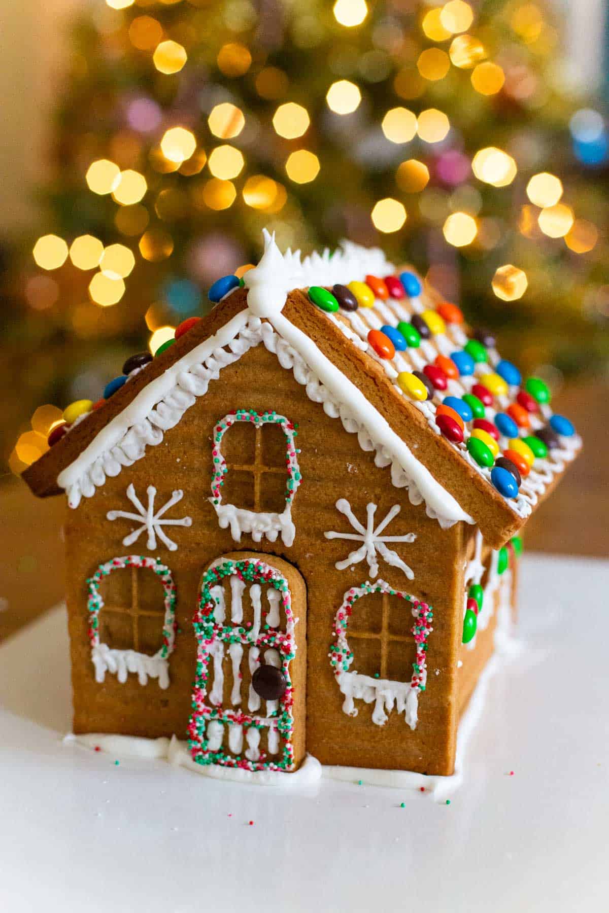 One example of how to decorate a gingerbread house with icing and icicles. Snowflakes are on the front of the house.