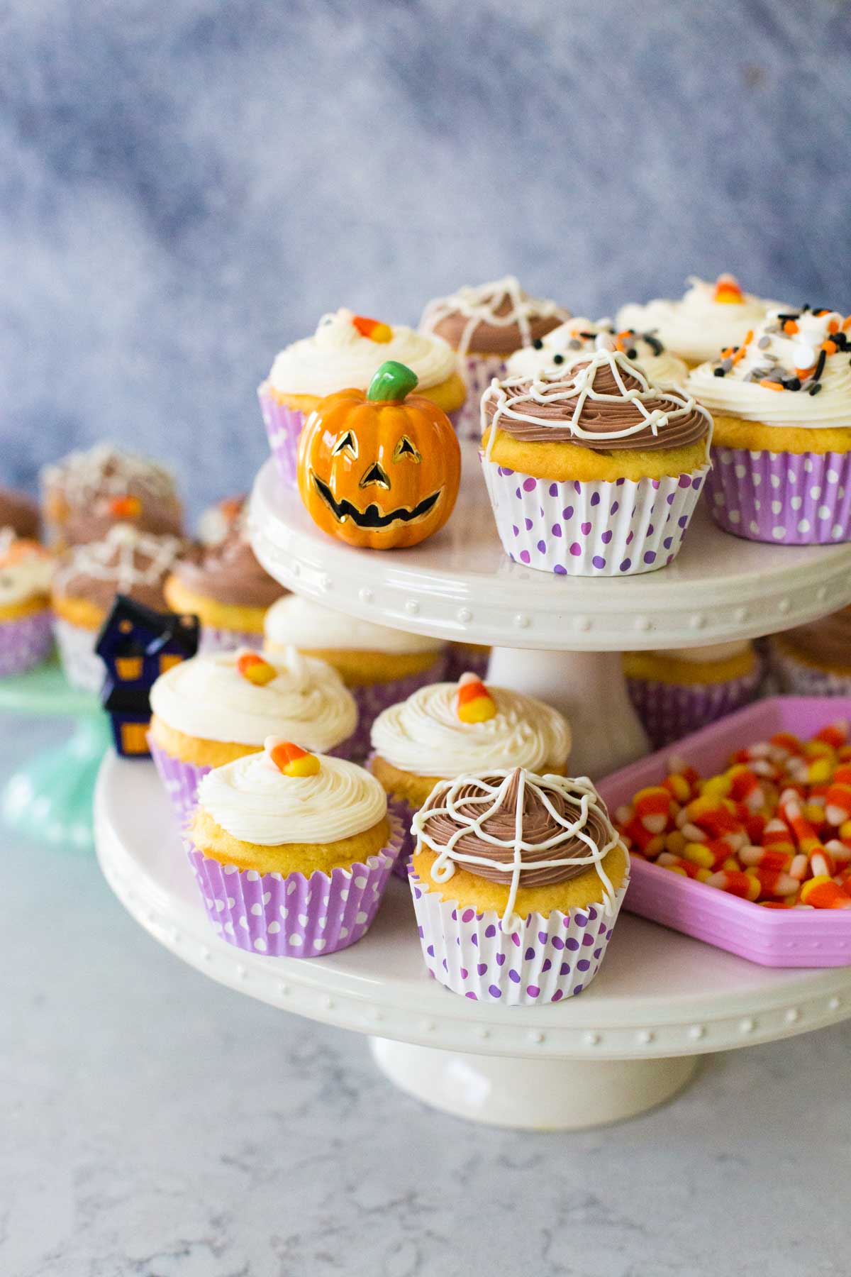 The frosted Halloween cupcakes feature chocolate spider webs, candy corn, and sprinkles.