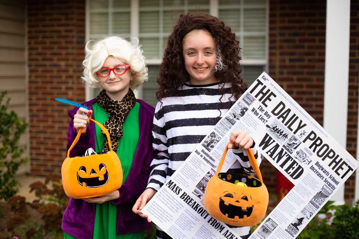 Two tween girls are dressed in Harry Potter costumes for trick or treating.