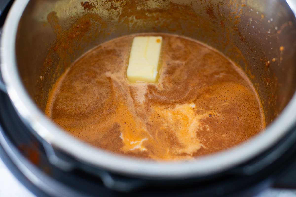 The butter is melting into the butter chicken sauce in the Instant Pot.