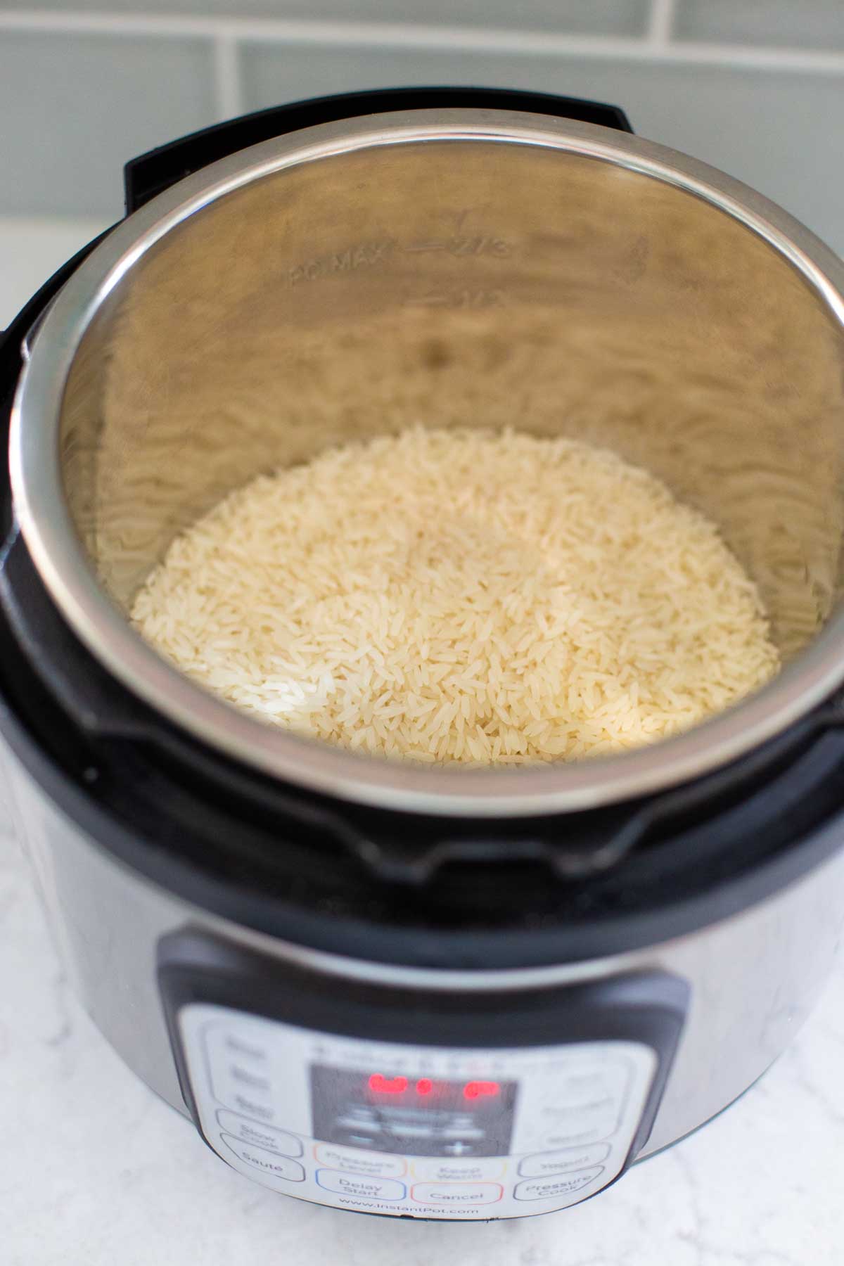 The dry white rice has been added to the Instant Pot pot.