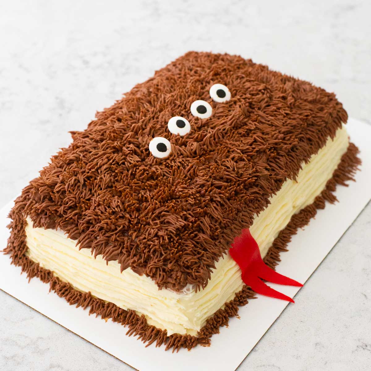 A Harry Potter "Monsters Book of Monsters" birthday cake has shaggy brown frosting like fur and a red tongue and googly eyes.