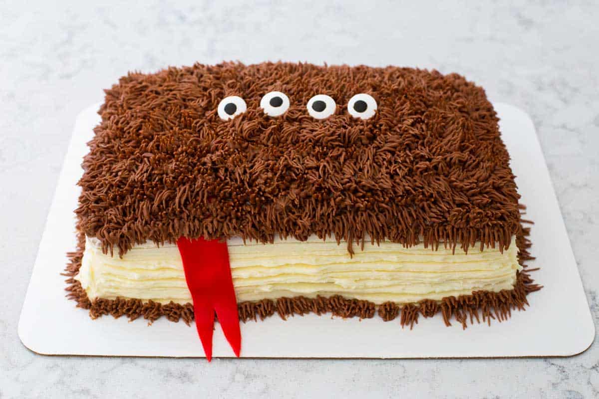 Add the red tongue of the monster before piping the fur on the top of the cake.