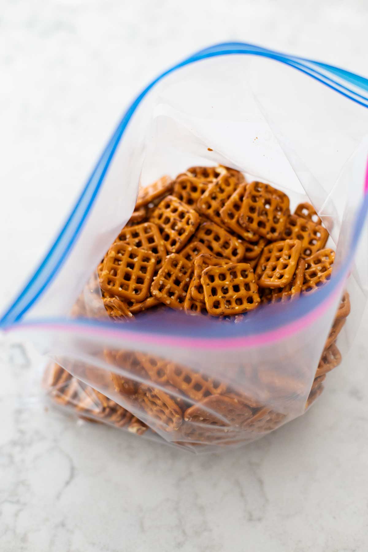 The pretzels have been poured into a large plastic ziptop bag.