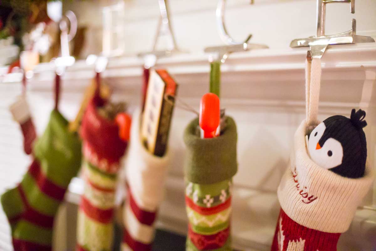 A row of Christmas stockings have been filled by St. Nicholas and are hanging on the mantel.