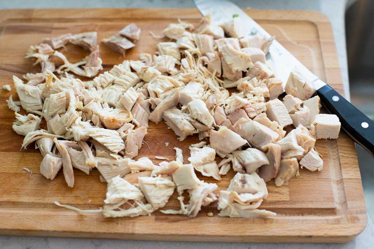 The cooked chicken has been cut into small pieces for the soup.