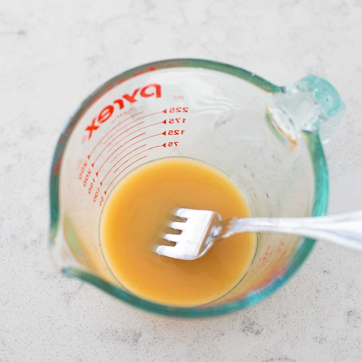 A fork has whisked in the cornstarch to the amaretto liqueur.