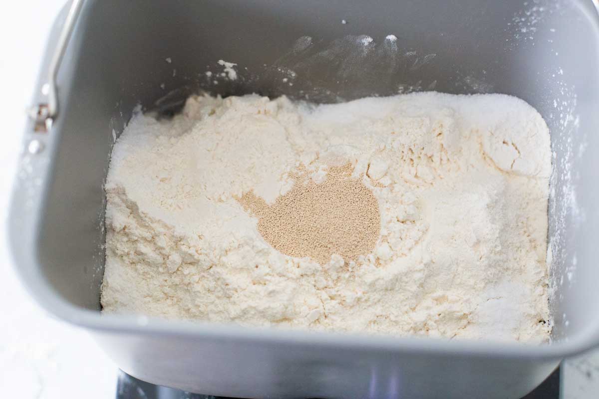 The flour, salt, and yeast have been added to the bread machine pan.