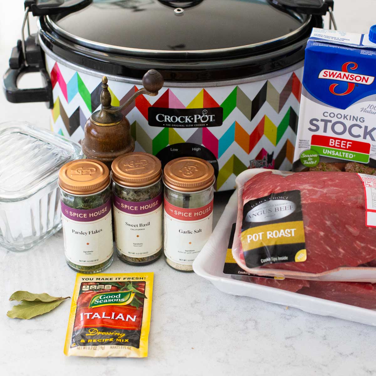 The ingredients for the italian beef are on the counter next to a Crockpot.