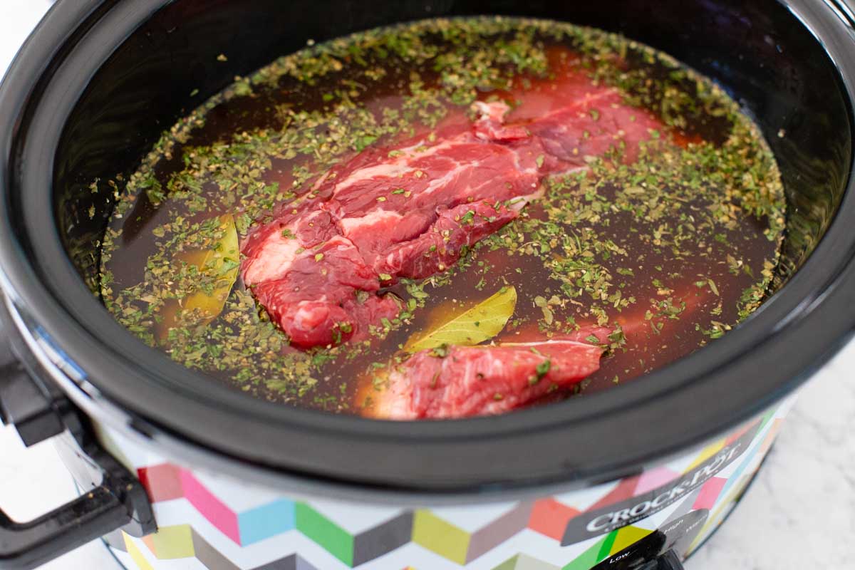 The beef has been added to the Italian broth in the slowcooker.