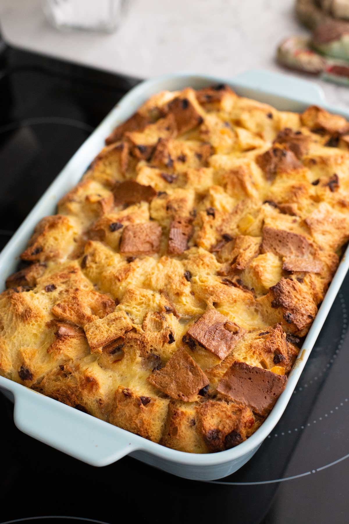 The panettone bread pudding is cooling slightly on the stovetop. It has a golden brown crust.