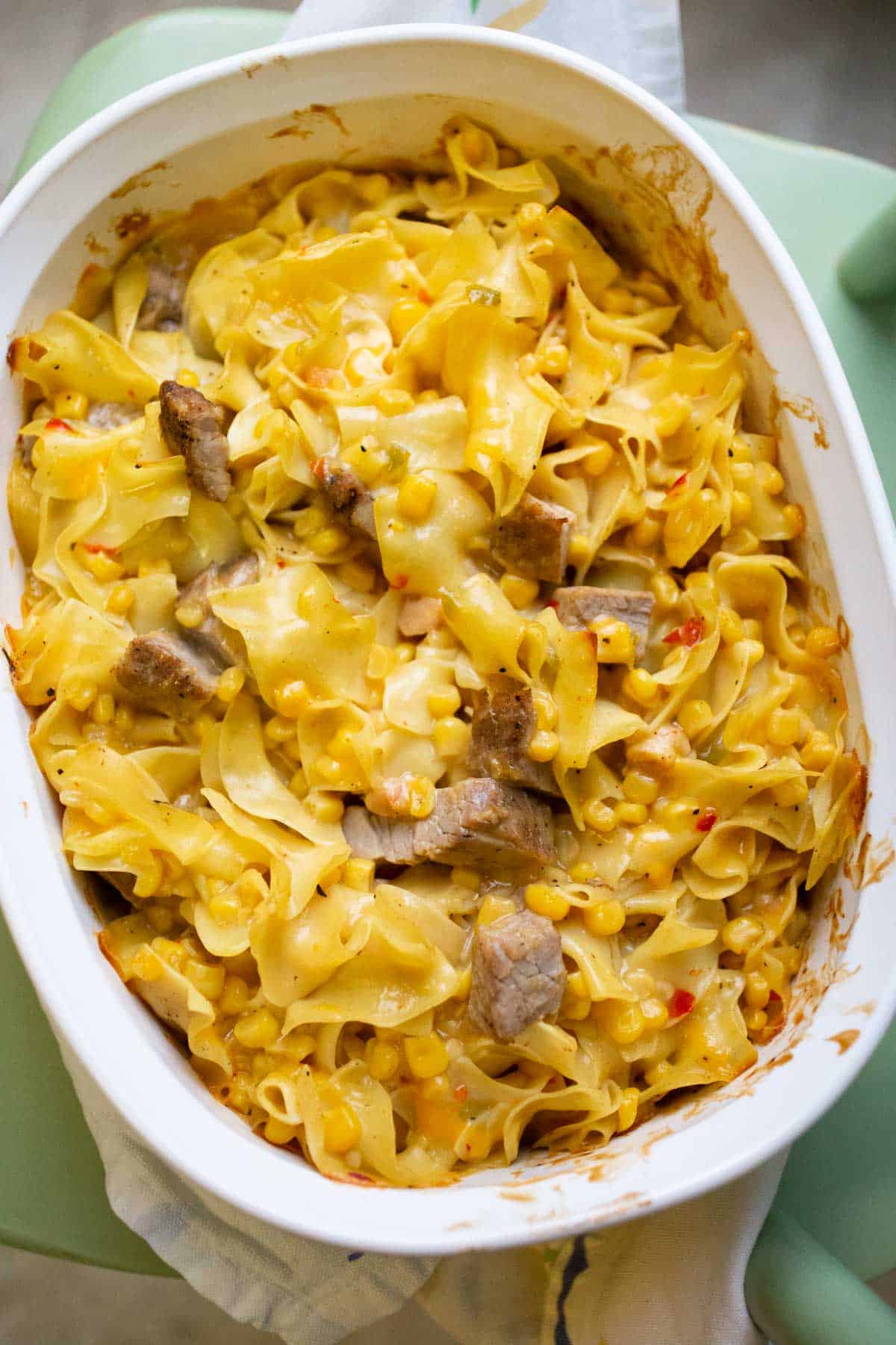 The leftover pork casserole has been baked and has a slightly crispy, golden brown top. 