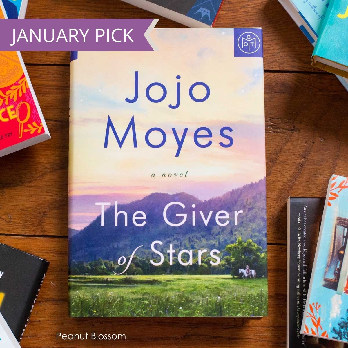 A copy of the book The Giver of Stars by Jojo Moyes sits on a table.