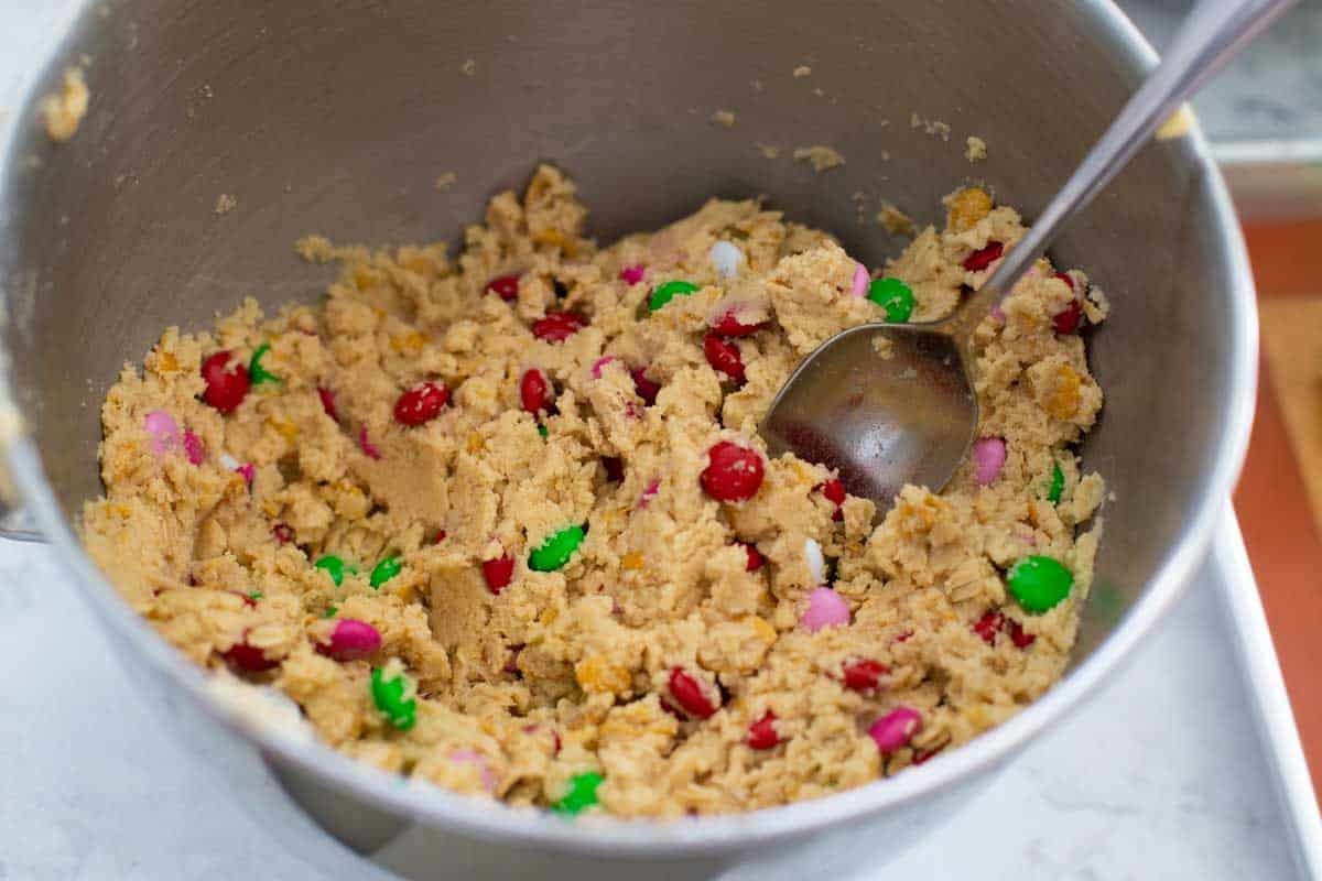 The cookie dough has been mixed in the metal mixing bowl.