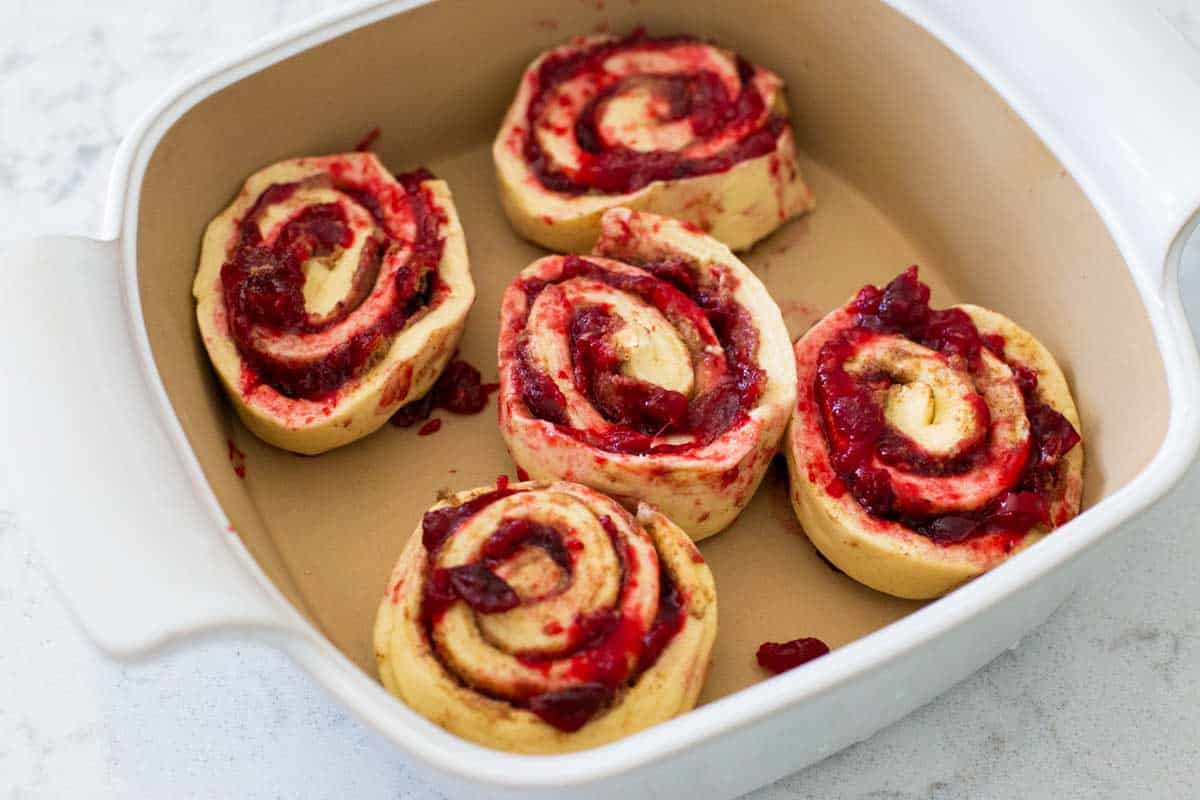 The cinnamon rolls are placed in a baking dish, cut side up.