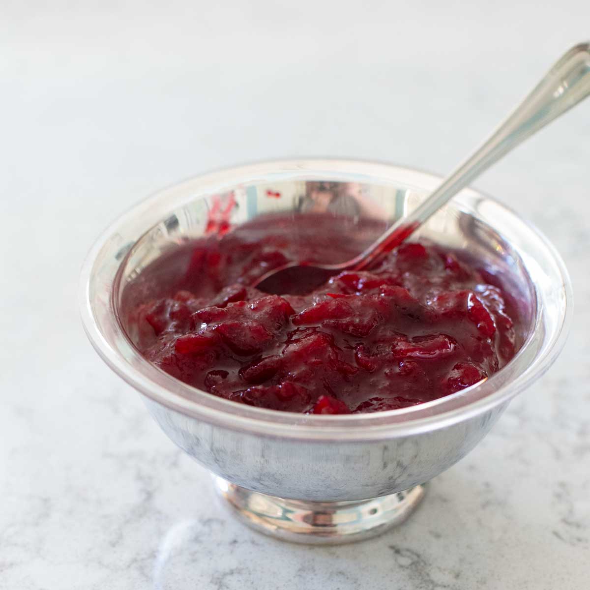 The cranberry sauce is in a silver serving bowl with a spoon.