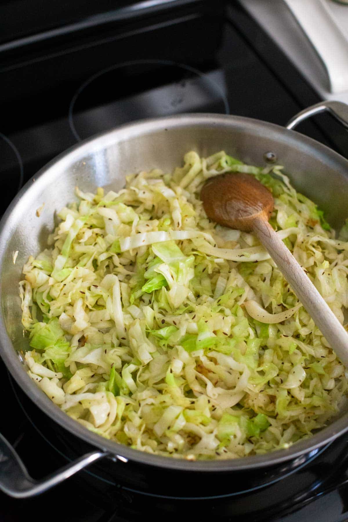 The cabbage has been cooked until browned and tossed in butter. Caraway seeds are sprinkled over the top.