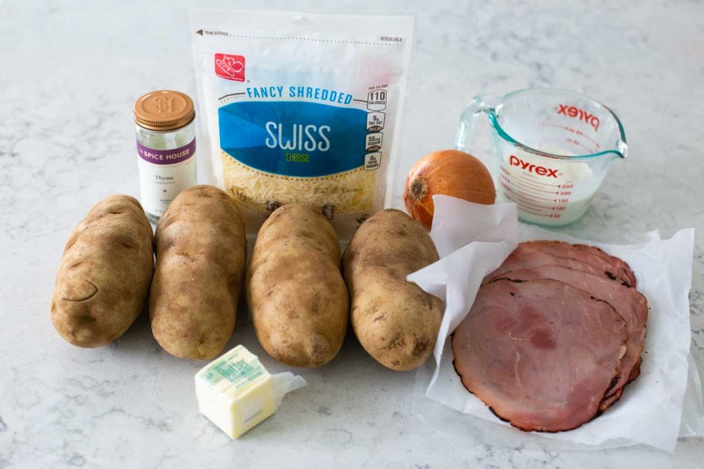 The ingredients to make ham and cheese potatoes are on the counter.
