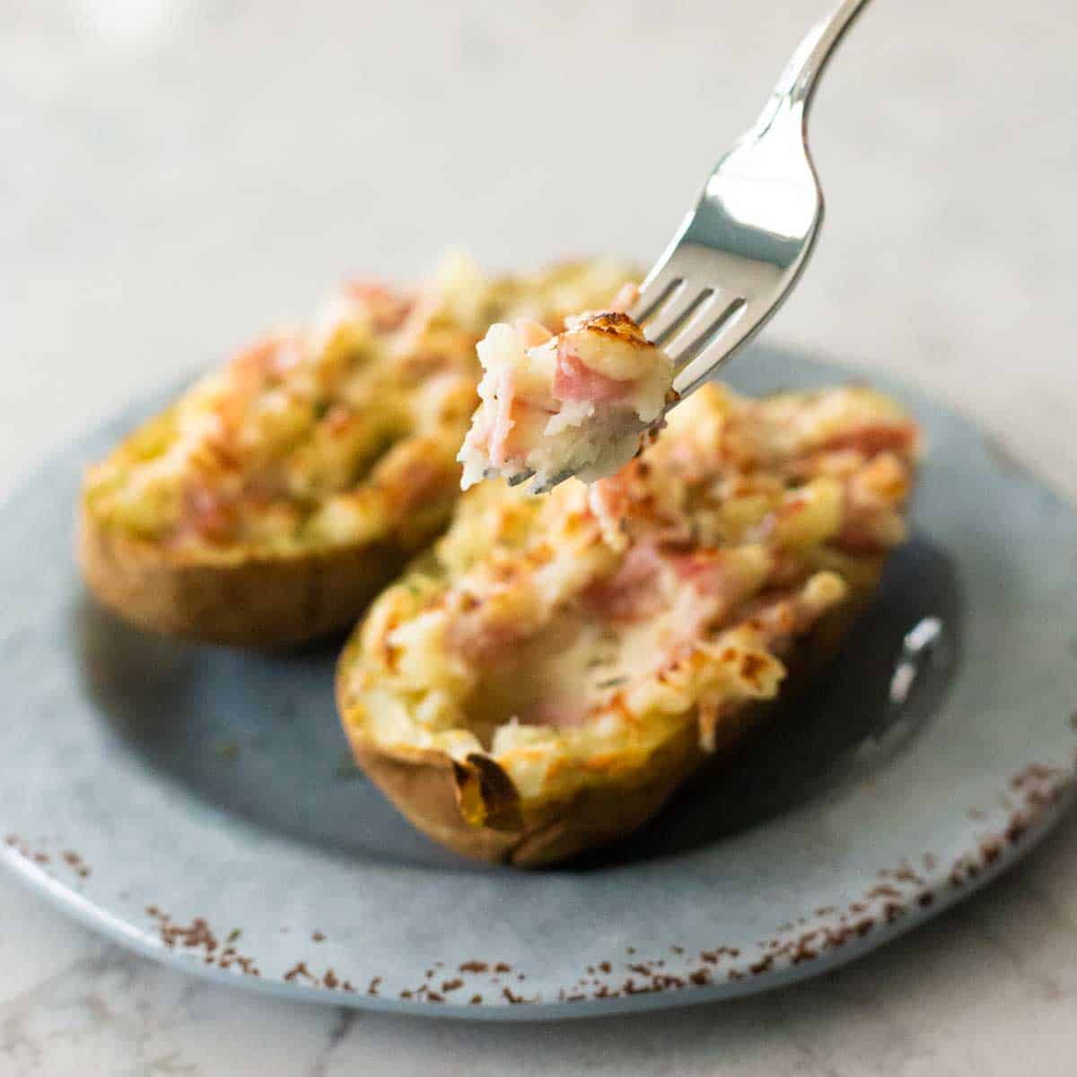 A fork is serving up a bite of the mashed potato filling.