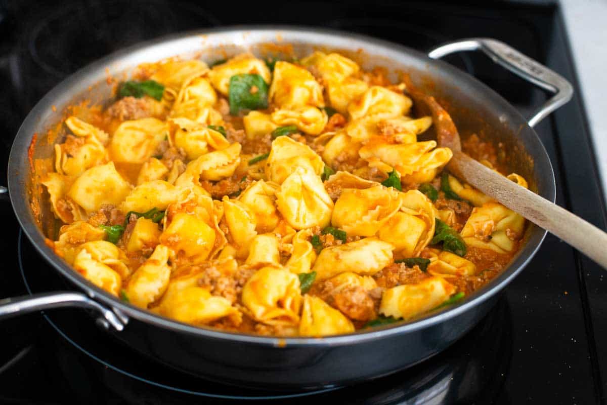 The tortellini have been added to the skillet and are ready for the oven.