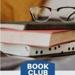 A pile of books with a pair of glasses on top.