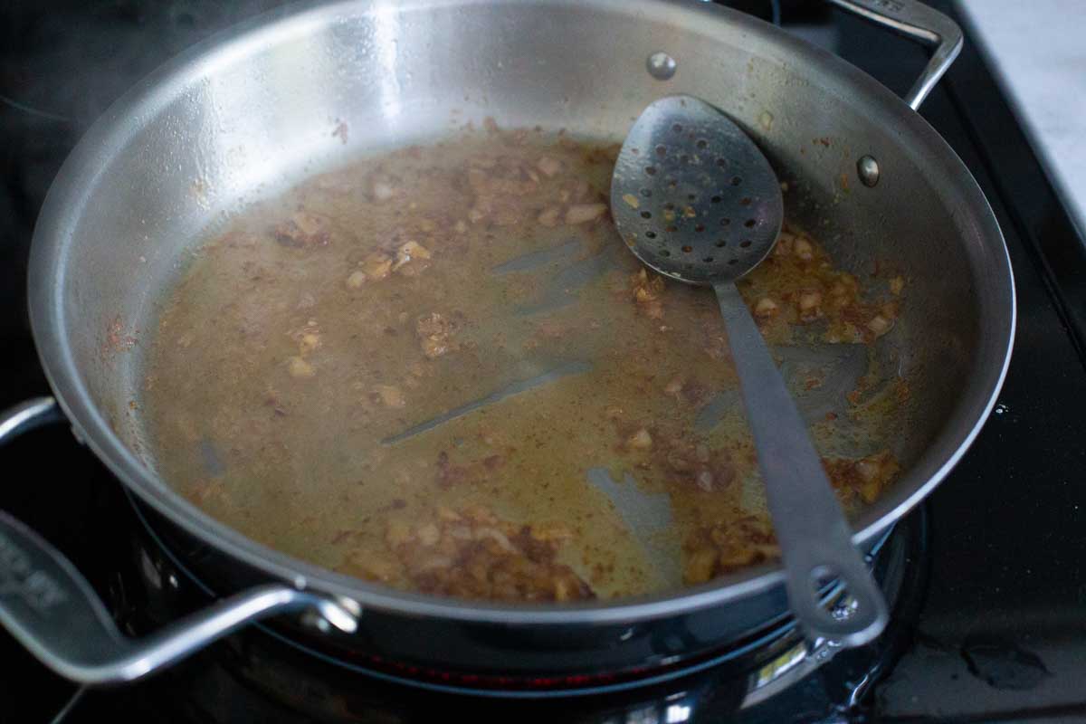 The meatballs have been removed and the pan is being deglazed.