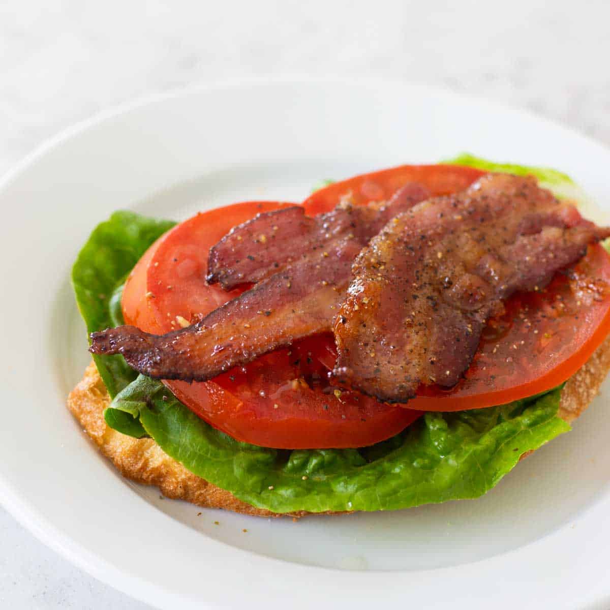 An open face BLT Sandwich shows off the inside ingredients before slicing.