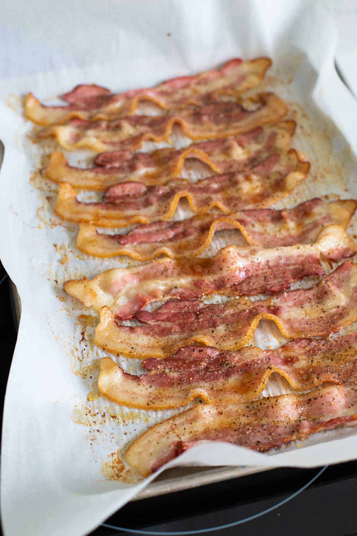 The bacon has been baked for the first 9 minutes and is just starting to brown.