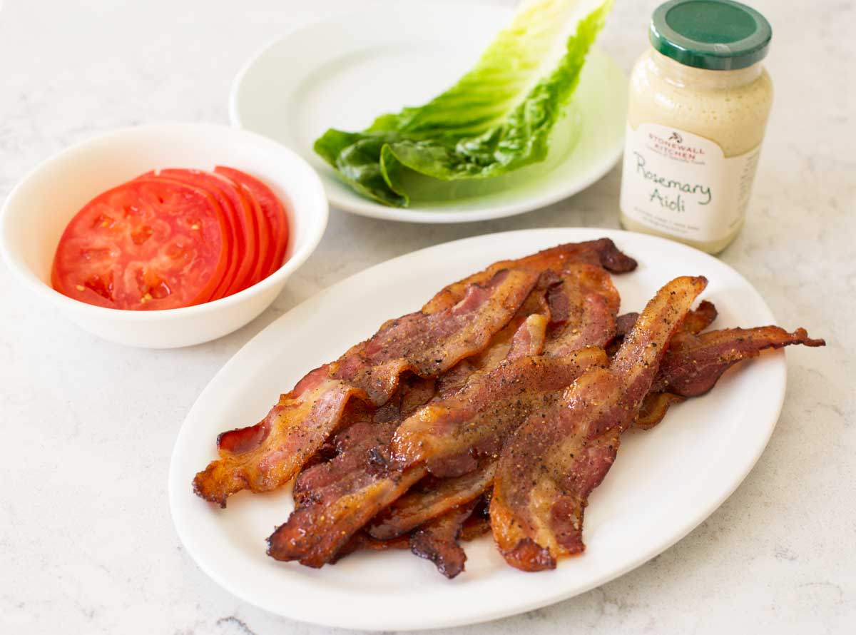 The ingredients to make a BLT sandwich are on the counter.