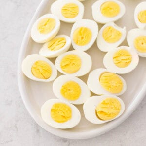 A platter of hard boiled eggs have been sliced open so you can see the perfectly cooked yolks.