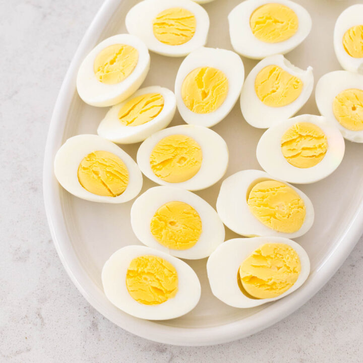 A platter of hard boiled eggs have been sliced open so you can see the perfectly cooked yolks.