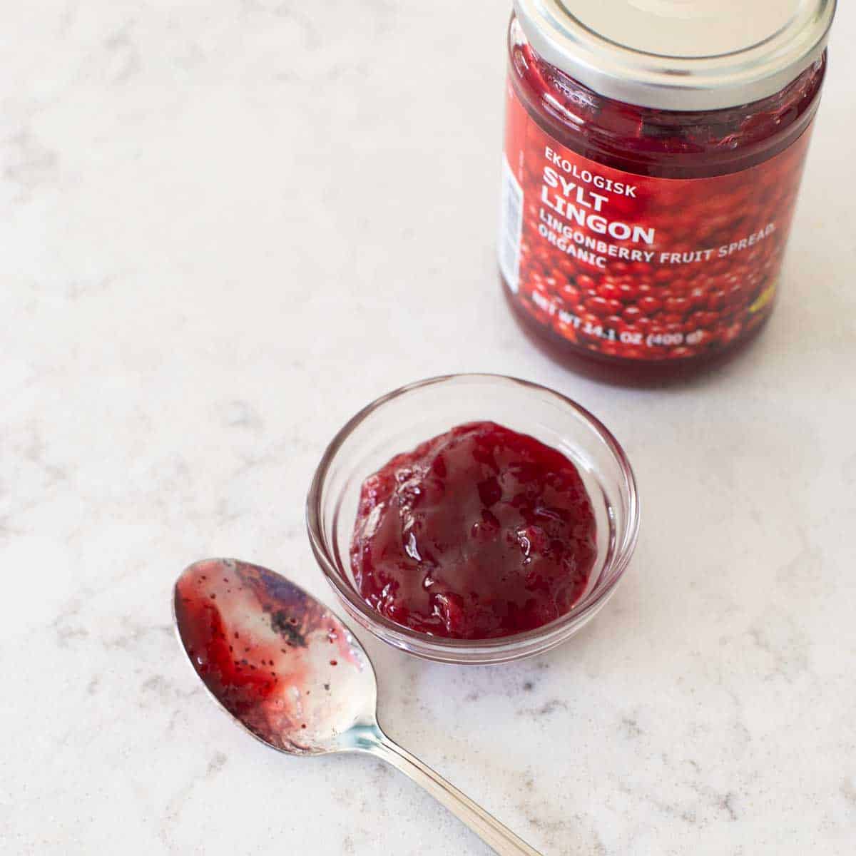 The jar of lingonberry jam has a spoon to show the texture.