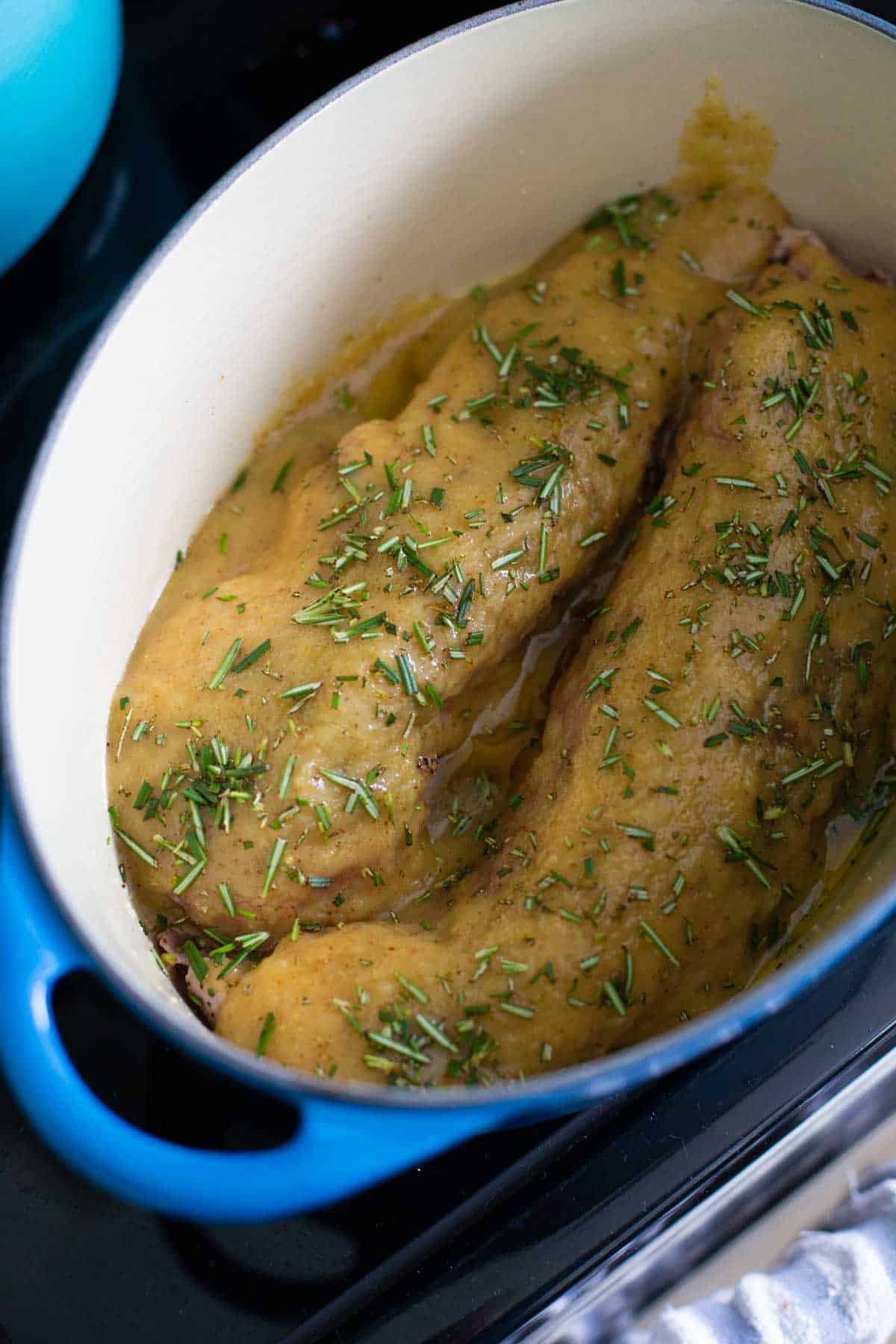 The marinade has been poured over the pork tenderloins in the dutch oven.