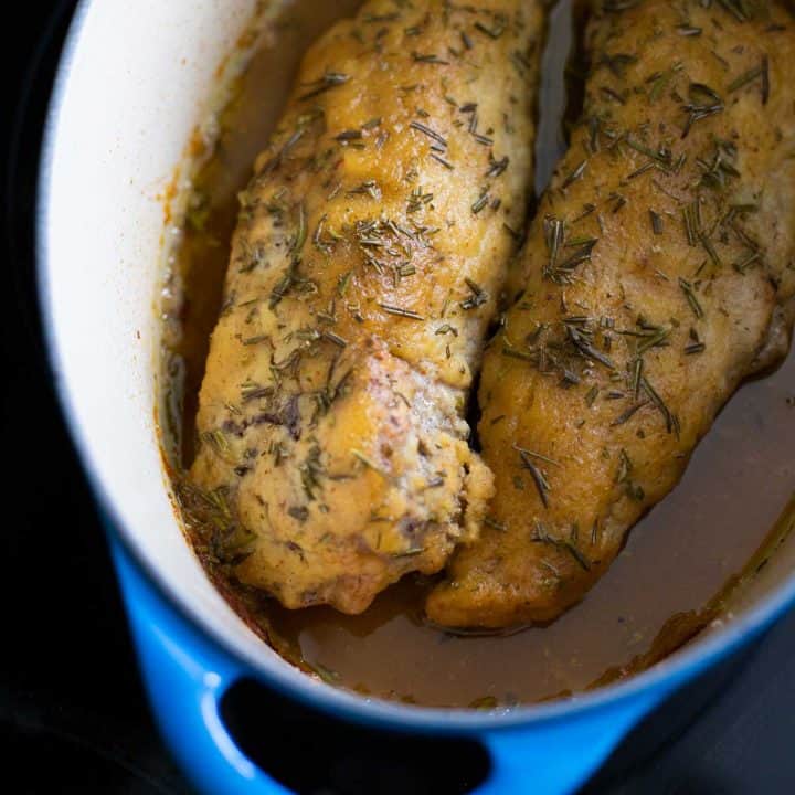 Two pork tenderloins in a dutch oven.