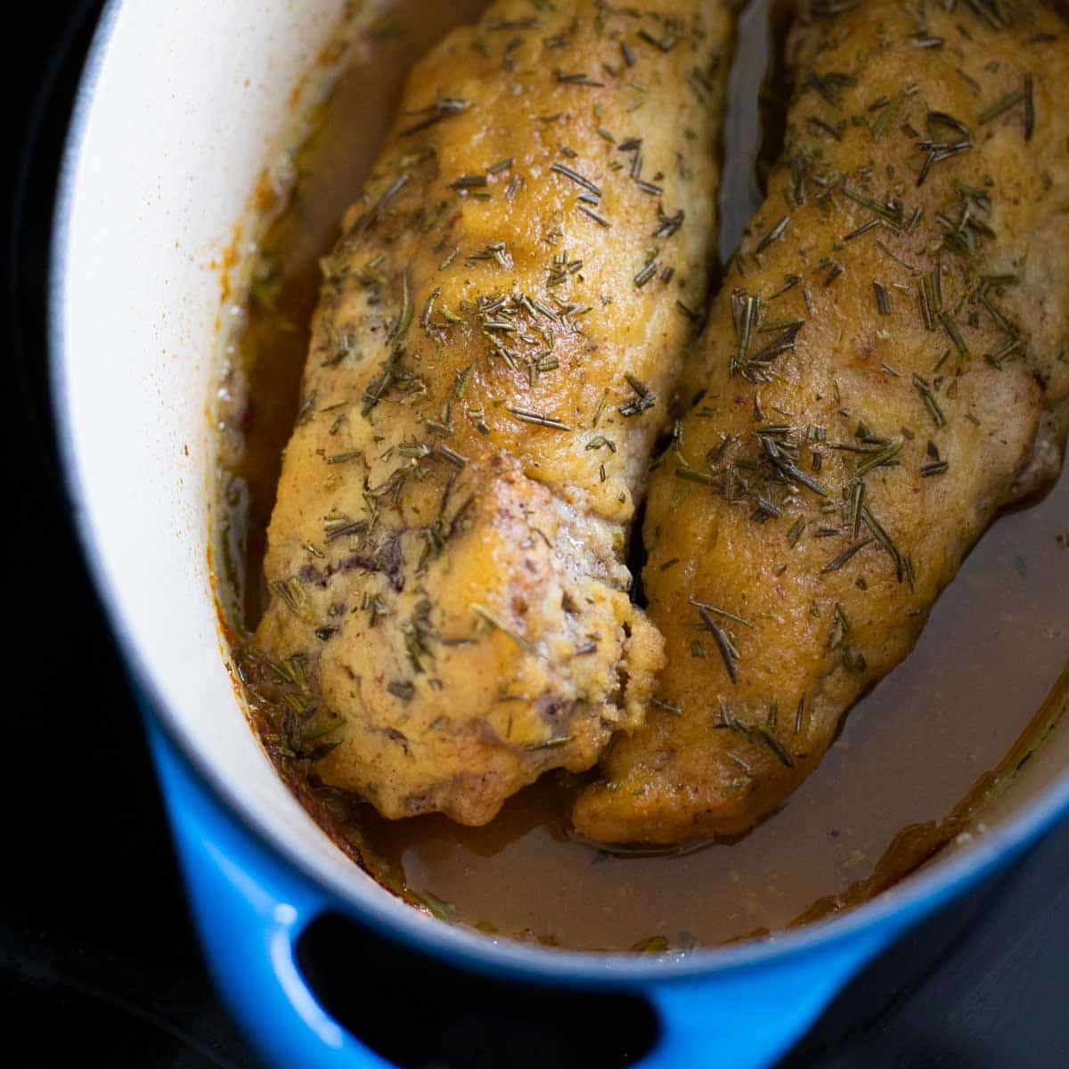 Two pork tenderloins in a dutch oven.