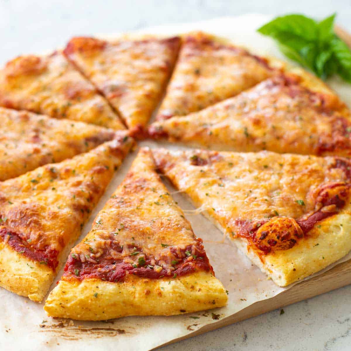 A homemade cheese pizza is sliced and ready to serve.