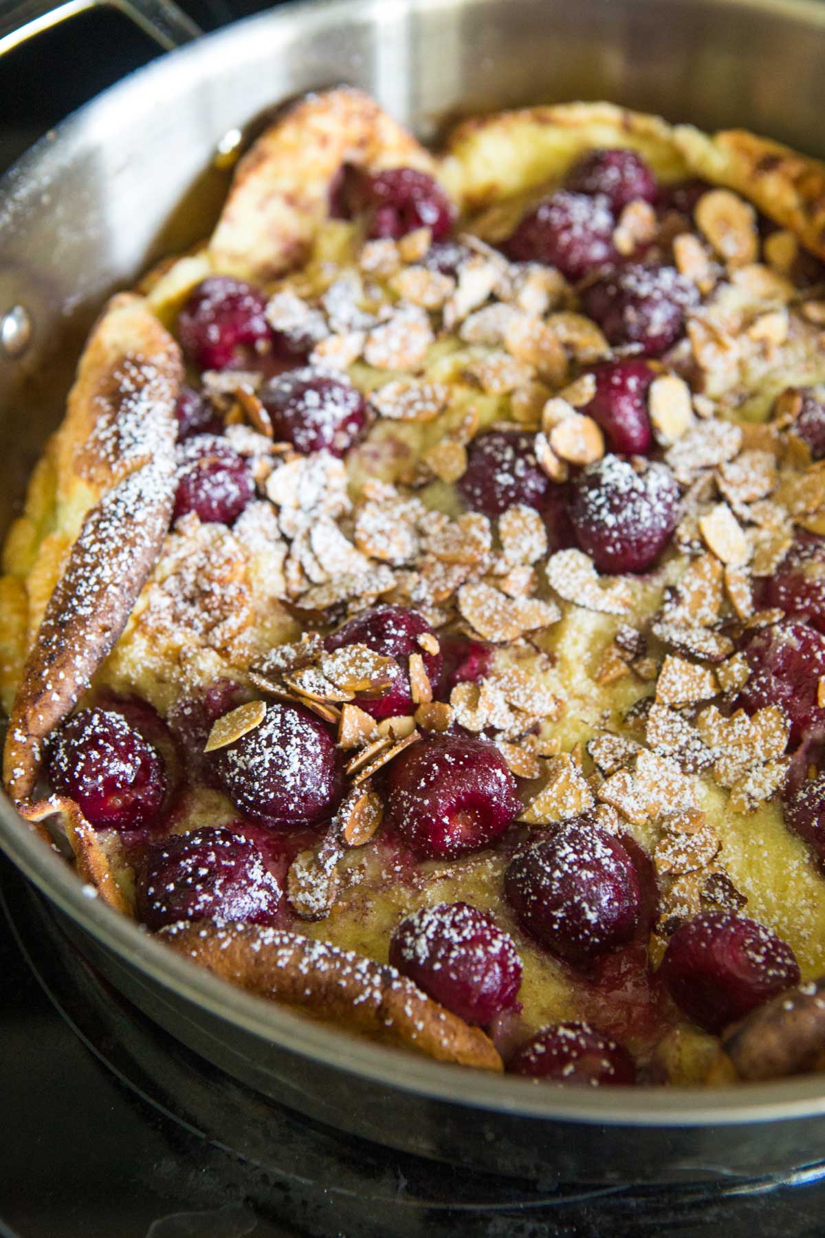 The baked cherry pancake with almonds and powdered sugar.