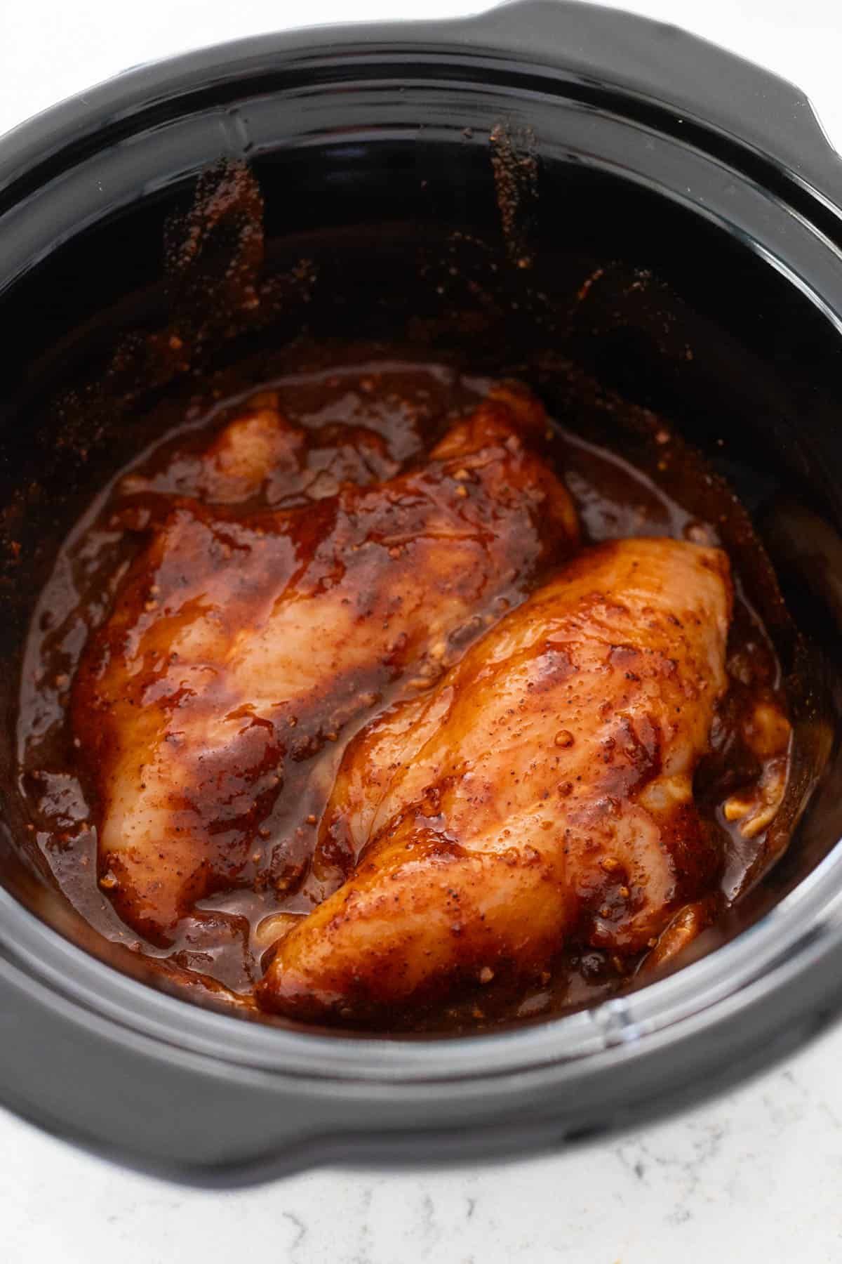 The saucy chicken breasts are ready to be cooked.
