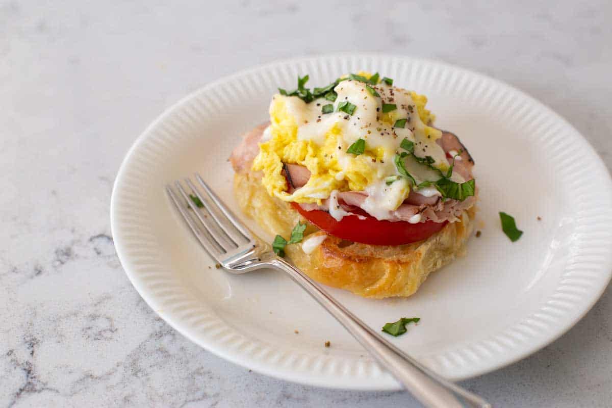 A croissant eggs benedict on a plate.