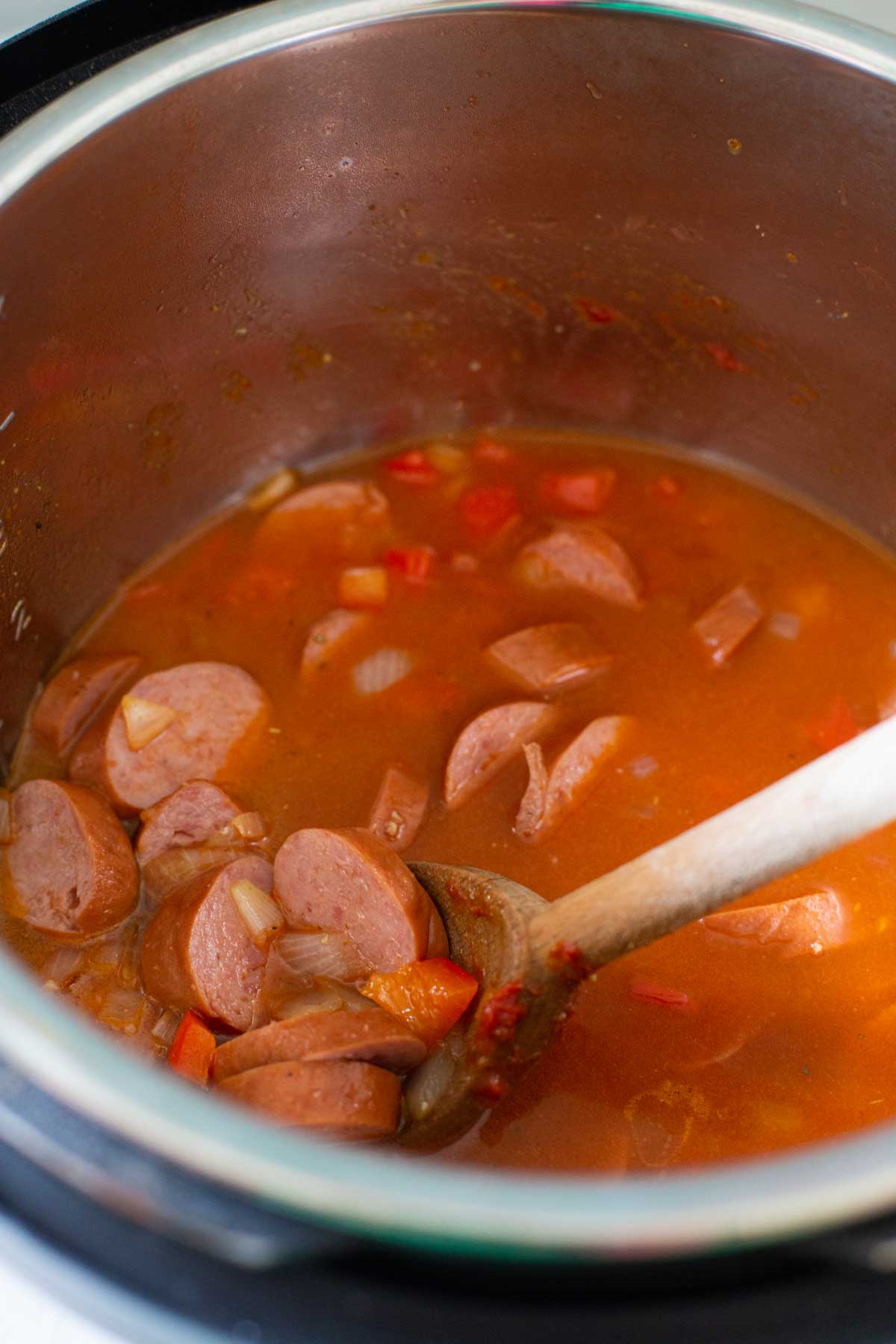 Brown the sausage and make the sauce before adding the rice to the Instant Pot.