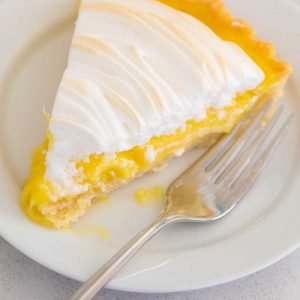 A piece of lemon pie with lemon curd filling.