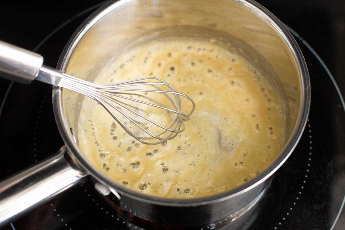 The flour and butter are being whisked and are bubbly.