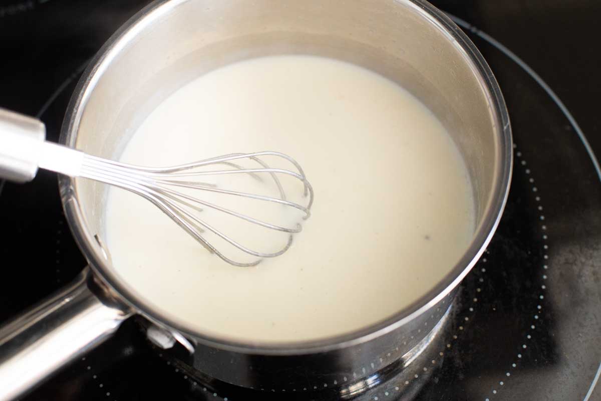 The milk has been drizzled into the butter in the pan.